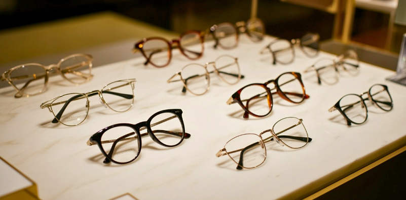 A wide selection of glasses frames displayed on a table top