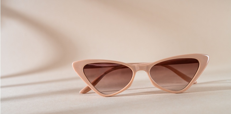 Cat eye frame sunglasses on a beige background.
