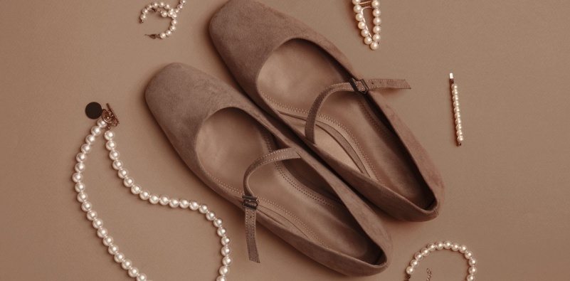 Shoes in Mocha Mousse shade and stylish accessories on dark beige background
